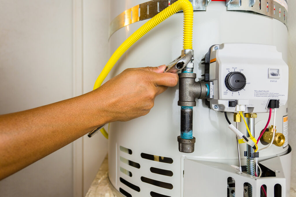 Licensed plumber repairing water heater in Cypress TX garage