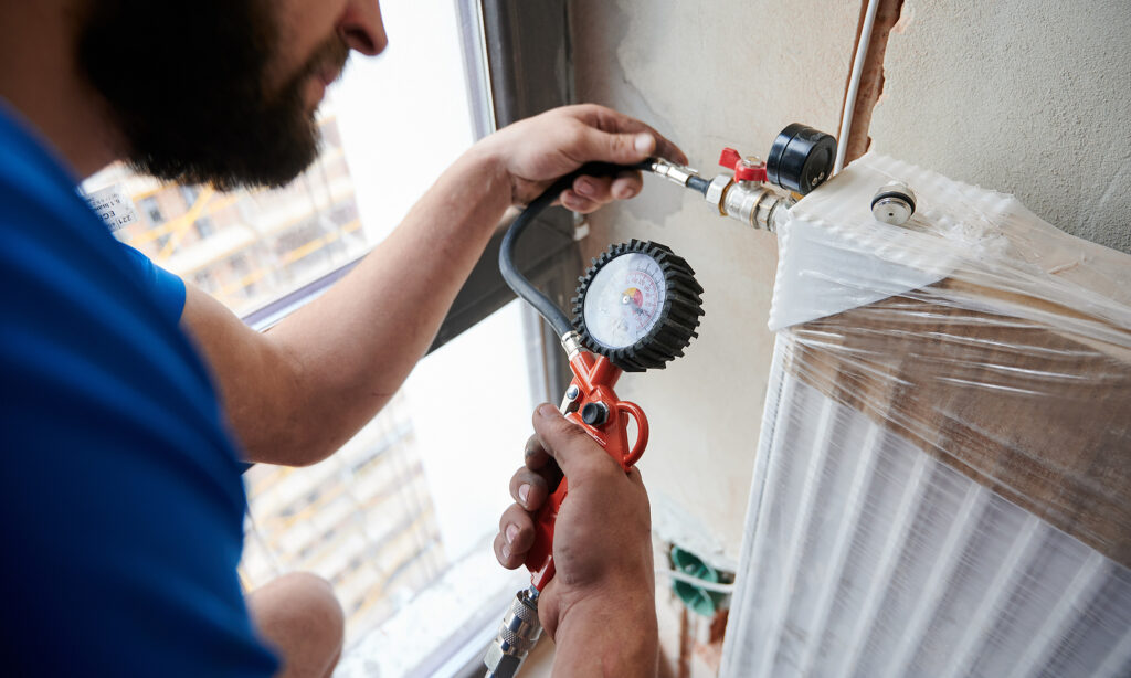 Licensed plumber using acoustic leak detection equipment in Cypress TX home