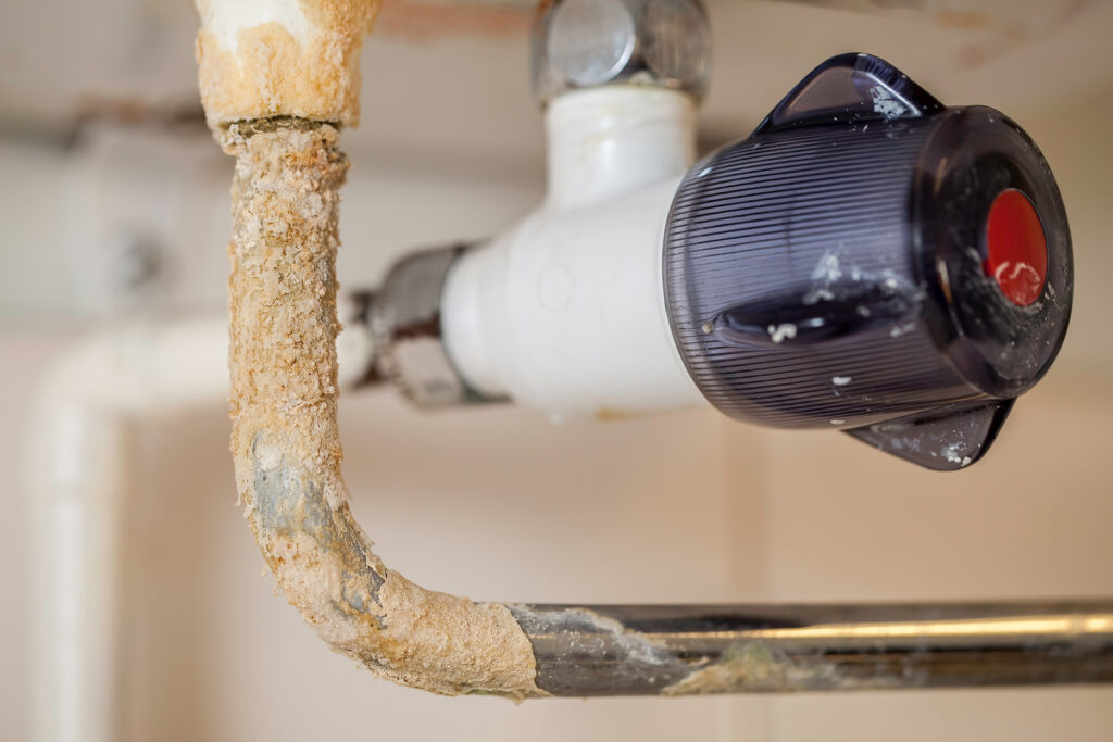 Scale buildup on water heater heating element showing hard water damage in Northwest Houston home